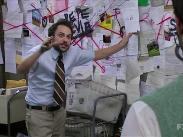 Meme of Charlie Day in slacks and a tie, looking over-caffeinated and obsessive, standing next to a corkboard covered with computer printouts and red twine